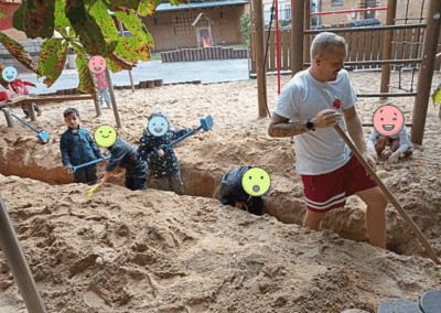 Teamwork im Sandkasten mit Kindern und Erziehern